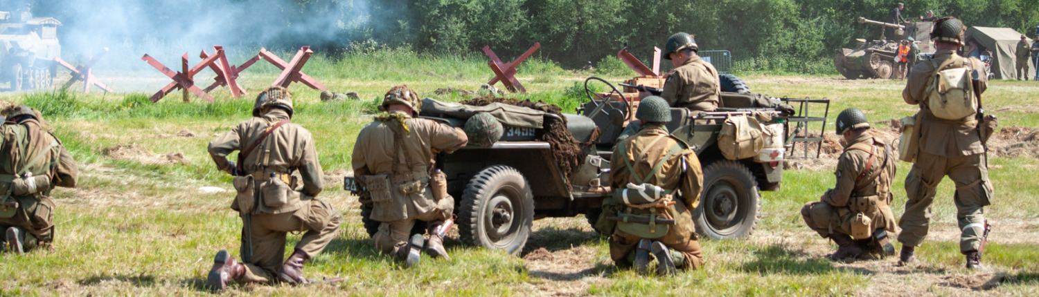 Soldiers gathered around a military vehicle, prepared for action.
