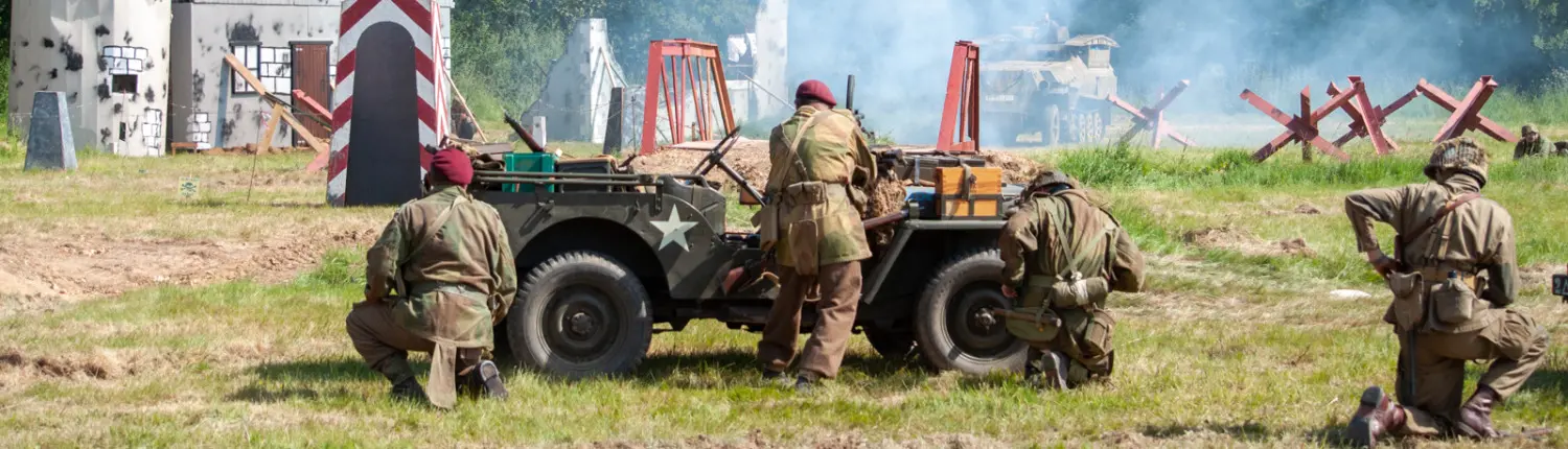 Soldiers in battle, standing by a military jeep, wearing uniforms.